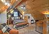 The loft queen bedroom offers a peaceful retreat, complete with a desk and chair.