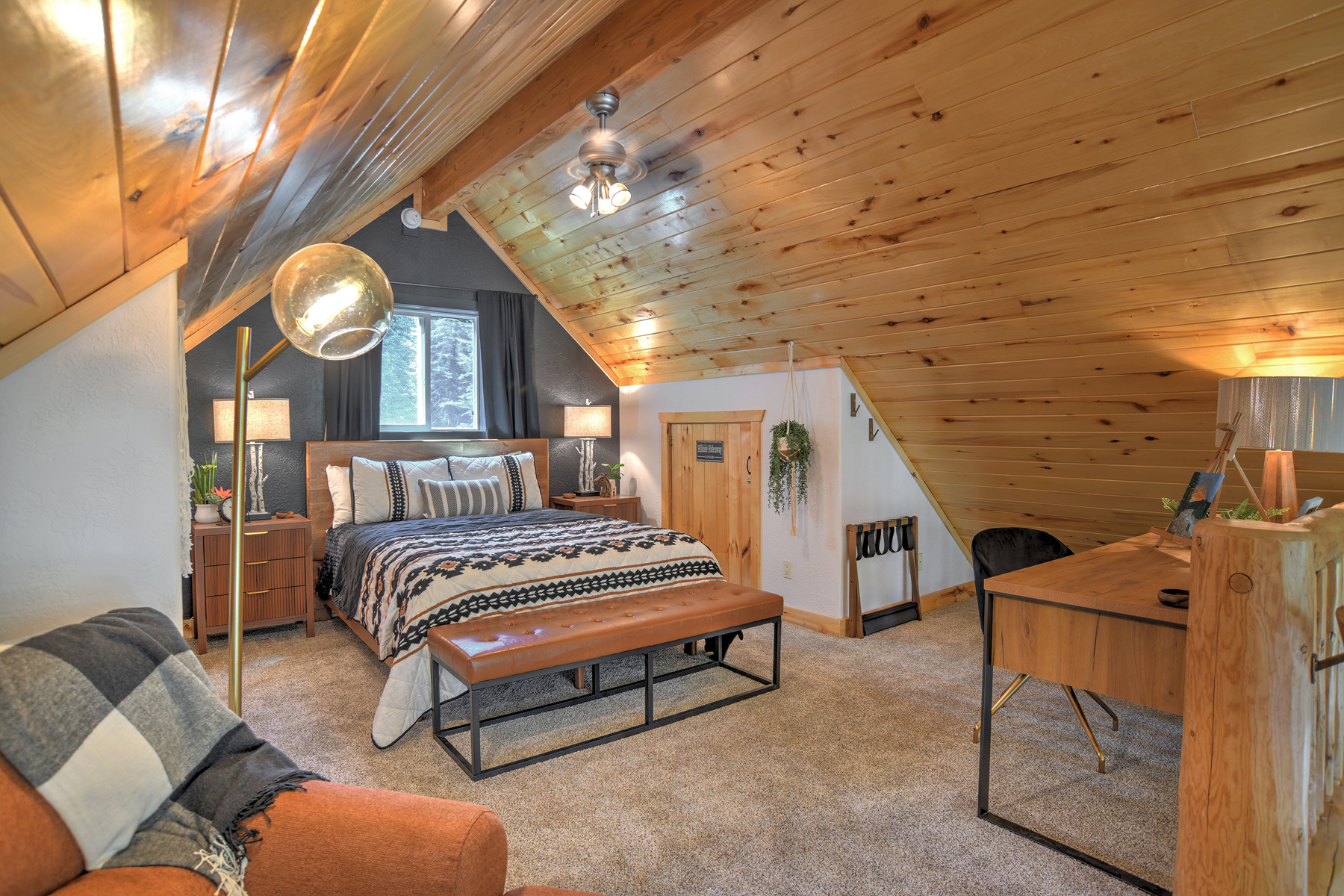 The loft queen bedroom offers a peaceful retreat, complete with a desk and chair.