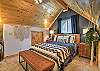 The loft queen bedroom offers a peaceful retreat, complete with a desk and chair.