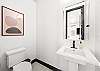 Conveniently located half bath with sleek sink and toilet. 