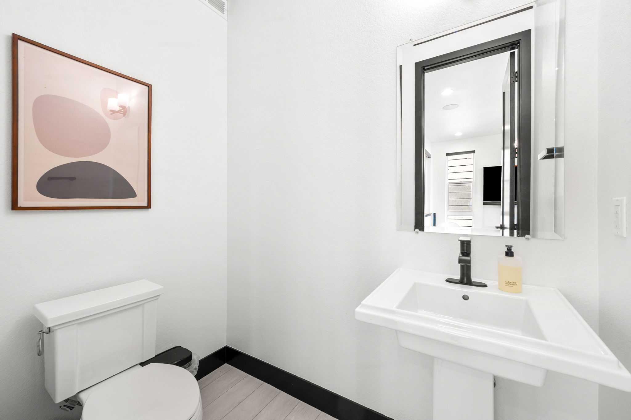 Conveniently located half bath with sleek sink and toilet. 