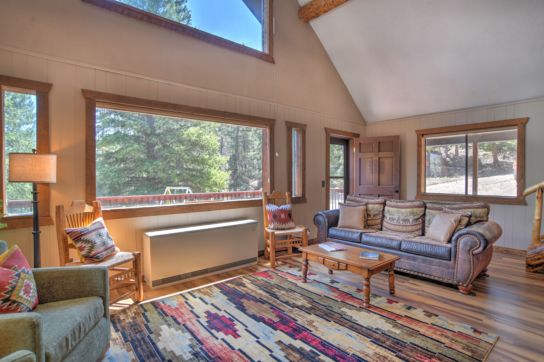 Living room with lots of windows perfect for enjoying the mountain and river views. 