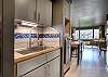 Small kitchen area with full-sized fridge, stove, oven and dish washer. 