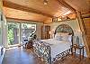 King bedroom with lots of windows and light.  Queen loft bed (not private) situated above. 