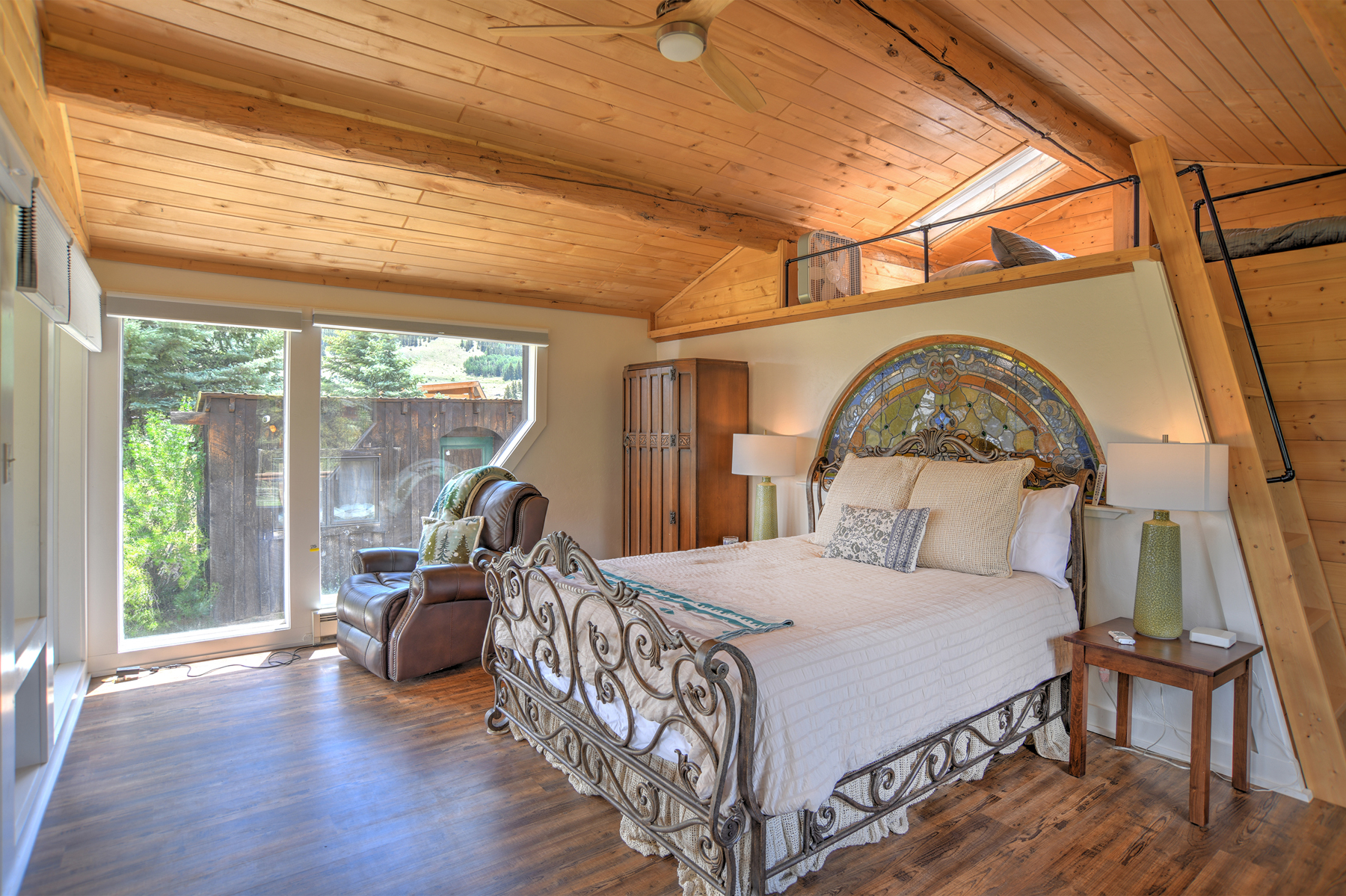 King bedroom with lots of windows and light. Queen loft bed (not private) situated above. 