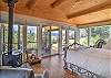 King bedroom with woodstove, two recliners, lots of windows, incredible views, and deck access.