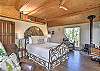 Main bedroom with king bed, wood stove, queen loft bed above (not private) and with access to the large deck. ,
