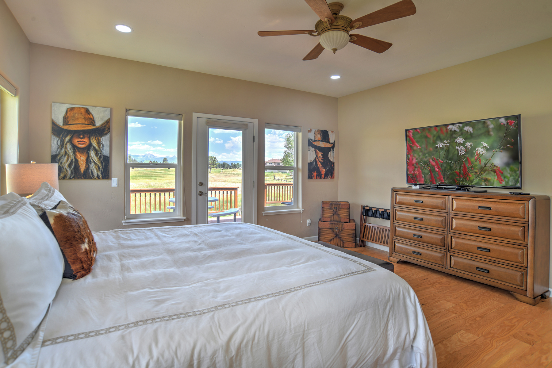 Main-level king bedroom with a king bed, a smart TV, and an ensuite bathroom. 