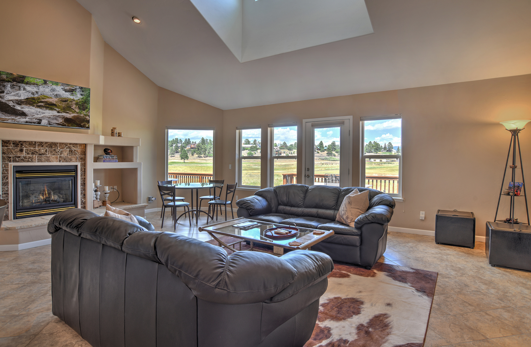 Our open living room offers a gas fireplace, mountain and golf course views, and access to our expansive back deck. 