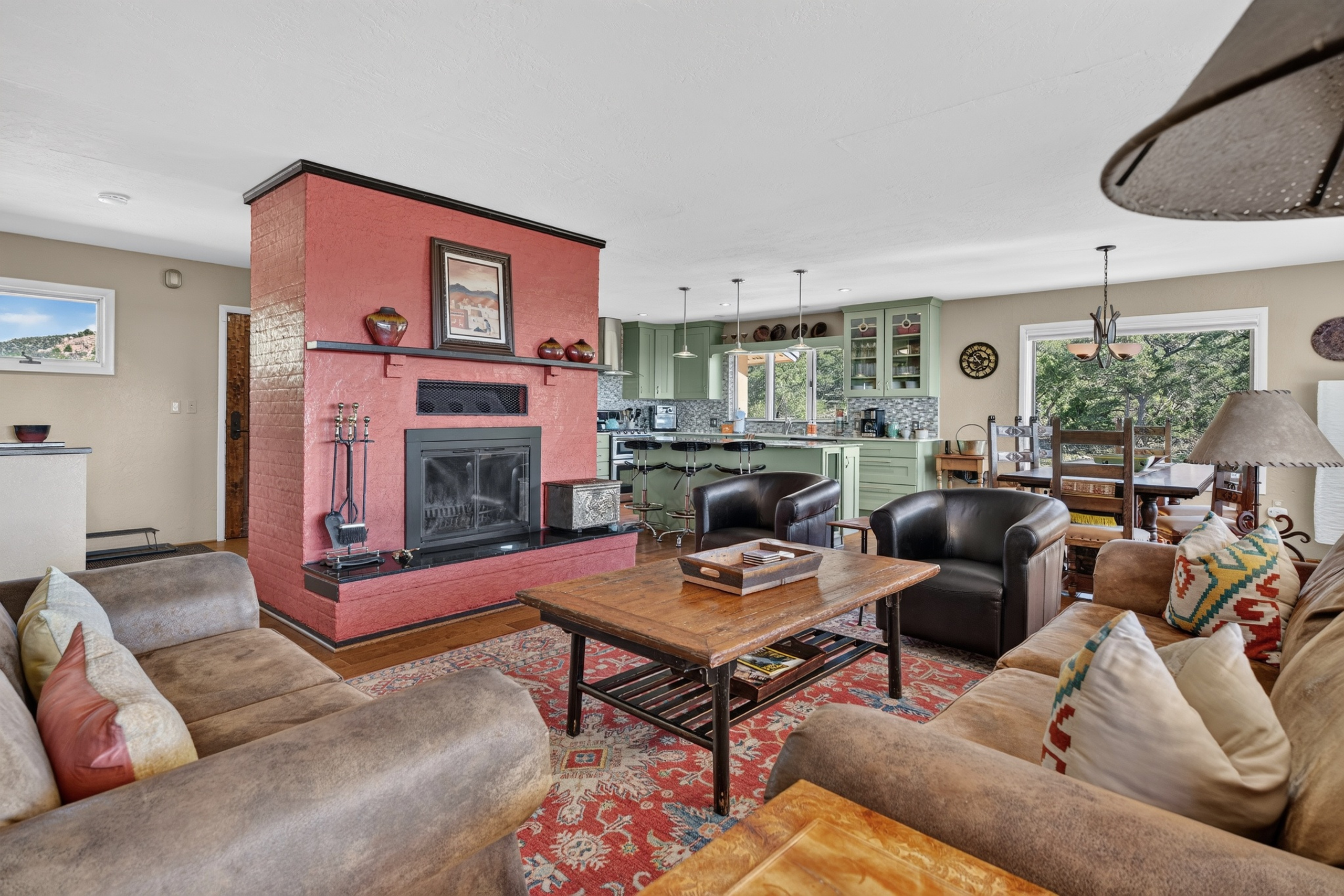 Living room with a piñon wood-burning fireplace and smartphone-ready soundbar.