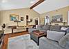 Game room with a regulation shuffleboard table, sectional sofa, smart TV, and a library of movies and games.