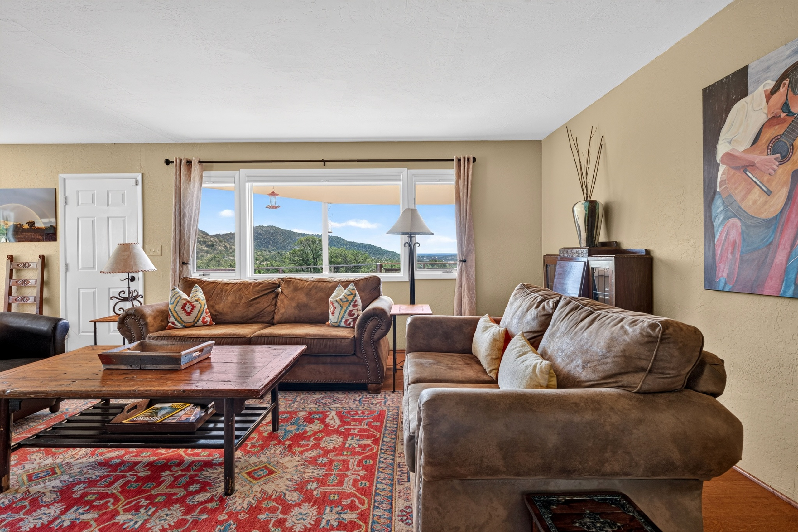Living room with a piñon wood-burning fireplace and smartphone-ready soundbar