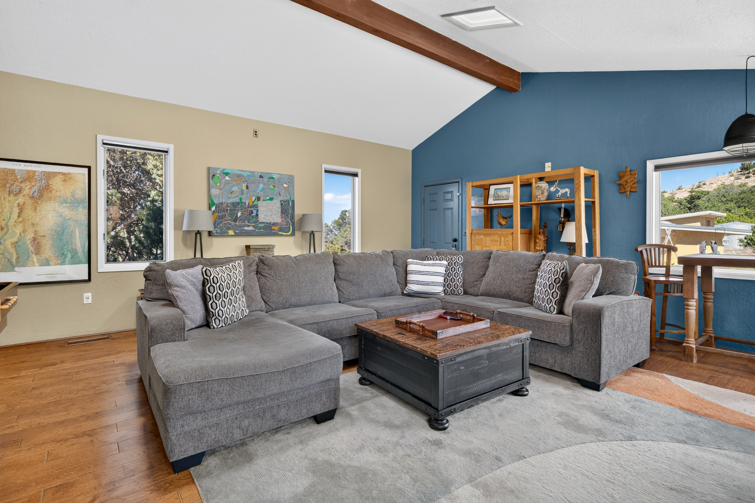 Game room with a regulation shuffleboard table, sectional sofa, smart TV, and a library of movies and games.