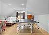 Bedroom with queen bed, living area, smart TV, and ping pong table.