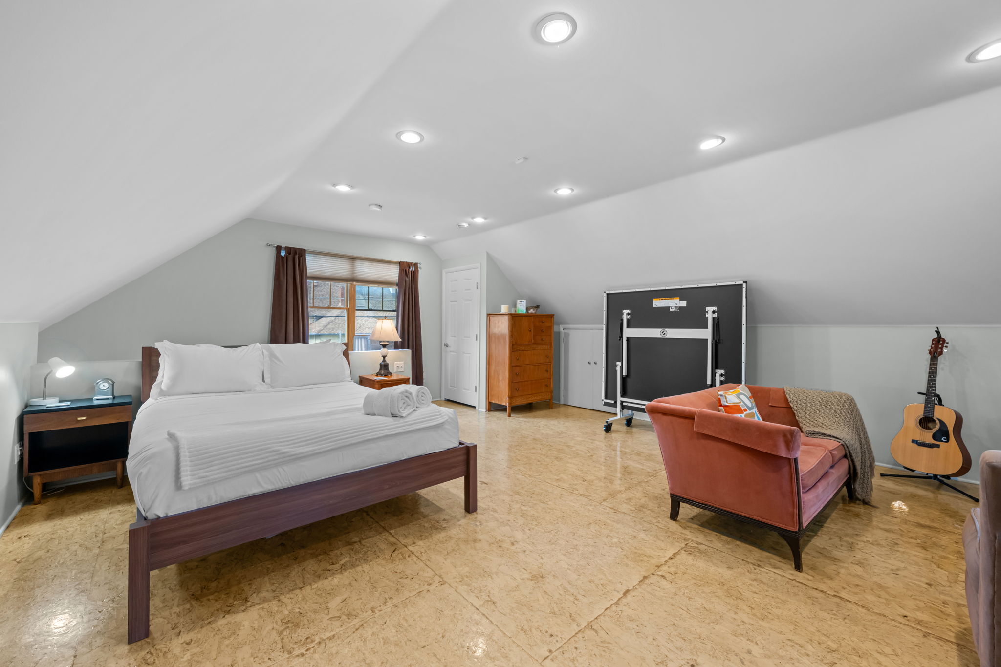 Bedroom with queen bed, living area, smart TV, and ping pong table.