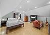 Bedroom with queen bed, living area, smart TV, and ping pong table.