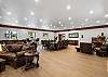 Great room with large fireplace, two Smart TVs, dining space for 14 people, lounging areas, antique piano, pool table, and bar. 