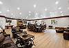 Great room with large fireplace, two Smart TVs, dining space for 14 people, lounging areas, antique piano, pool table, and bar. 