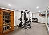Yoga and wellness room with home gym, stationary bike, and private two-person sauna.