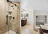 Primary ensuite bathroom featuring a sleek walk-in shower and vanity.