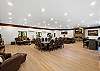 Great room with large fireplace, two Smart TVs, dining space for 14 people, lounging areas, antique piano, pool table, and bar. 