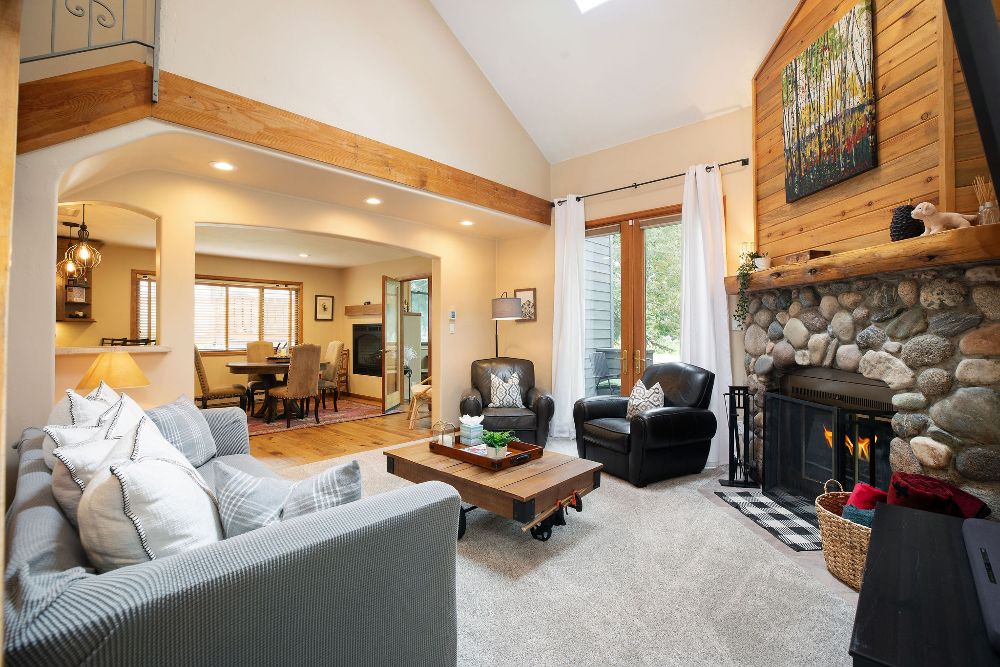 Living room with fireplace and sofa that converts into bed for additional sleeping space. 