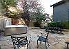 Large patio with outdoor seating and a private hot tub that fits all 12 guests