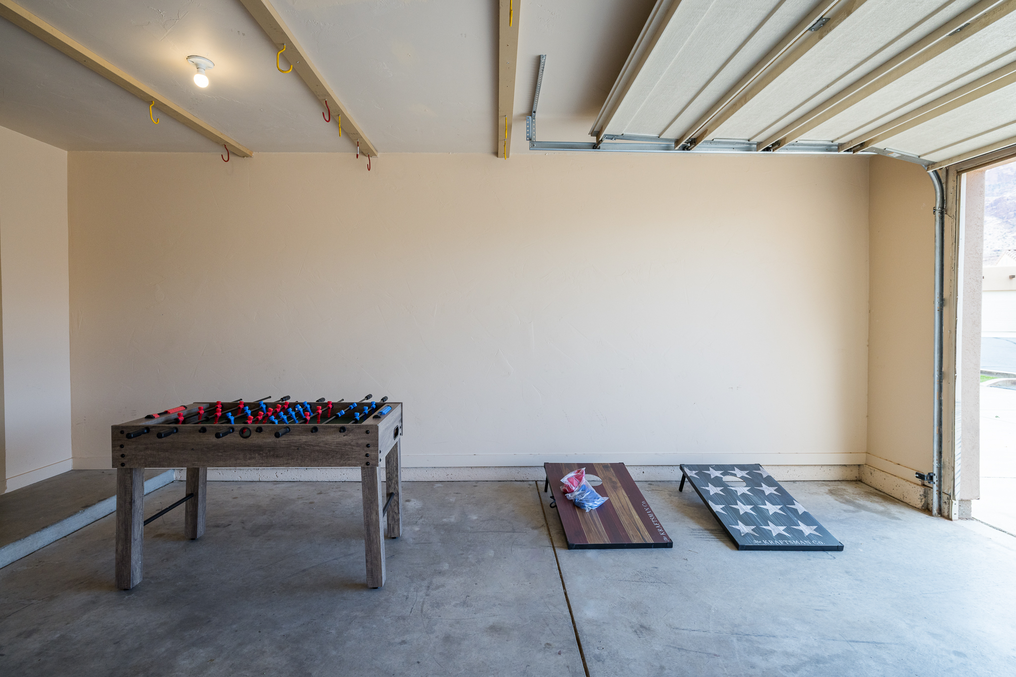 The garage includes a foosball table and corn hole. 
