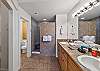The en suite bathroom features a walk-in shower, dual sinks, and a large closet.