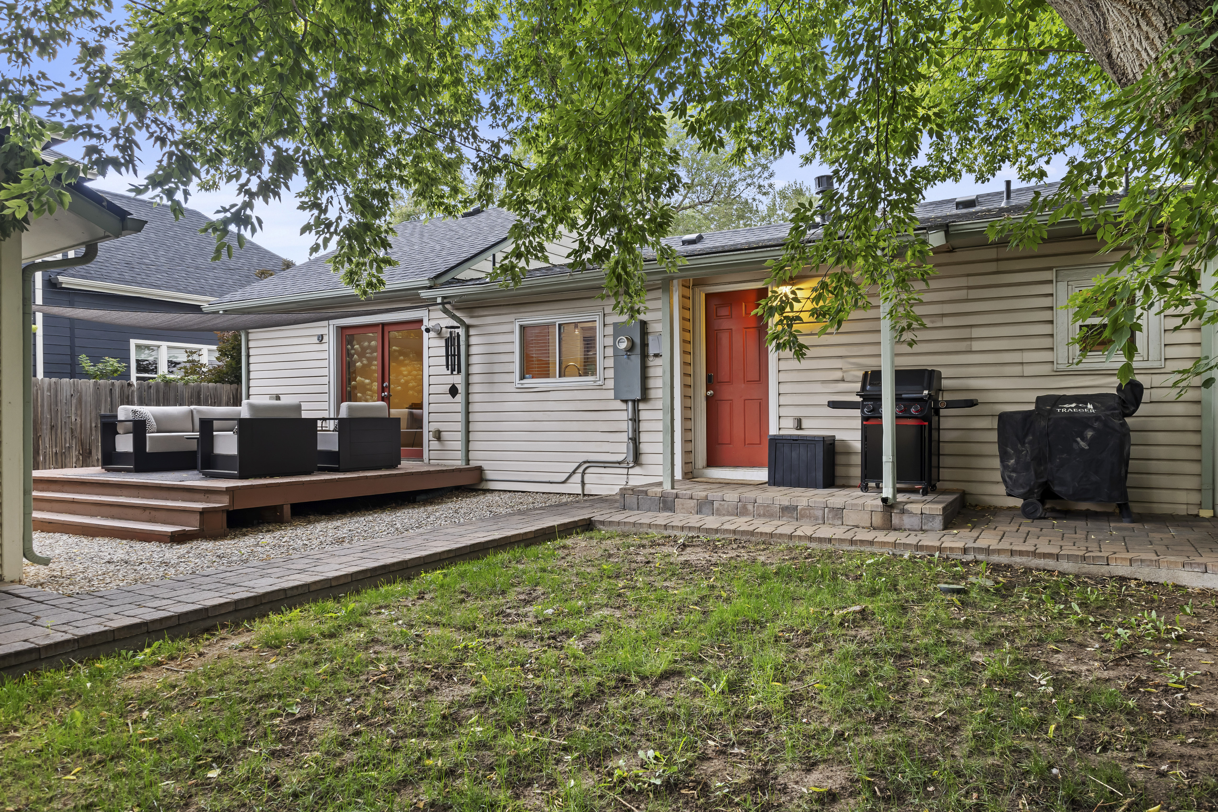 The fully fenced backyard includes a gas grill, patio area, and fire pit. 