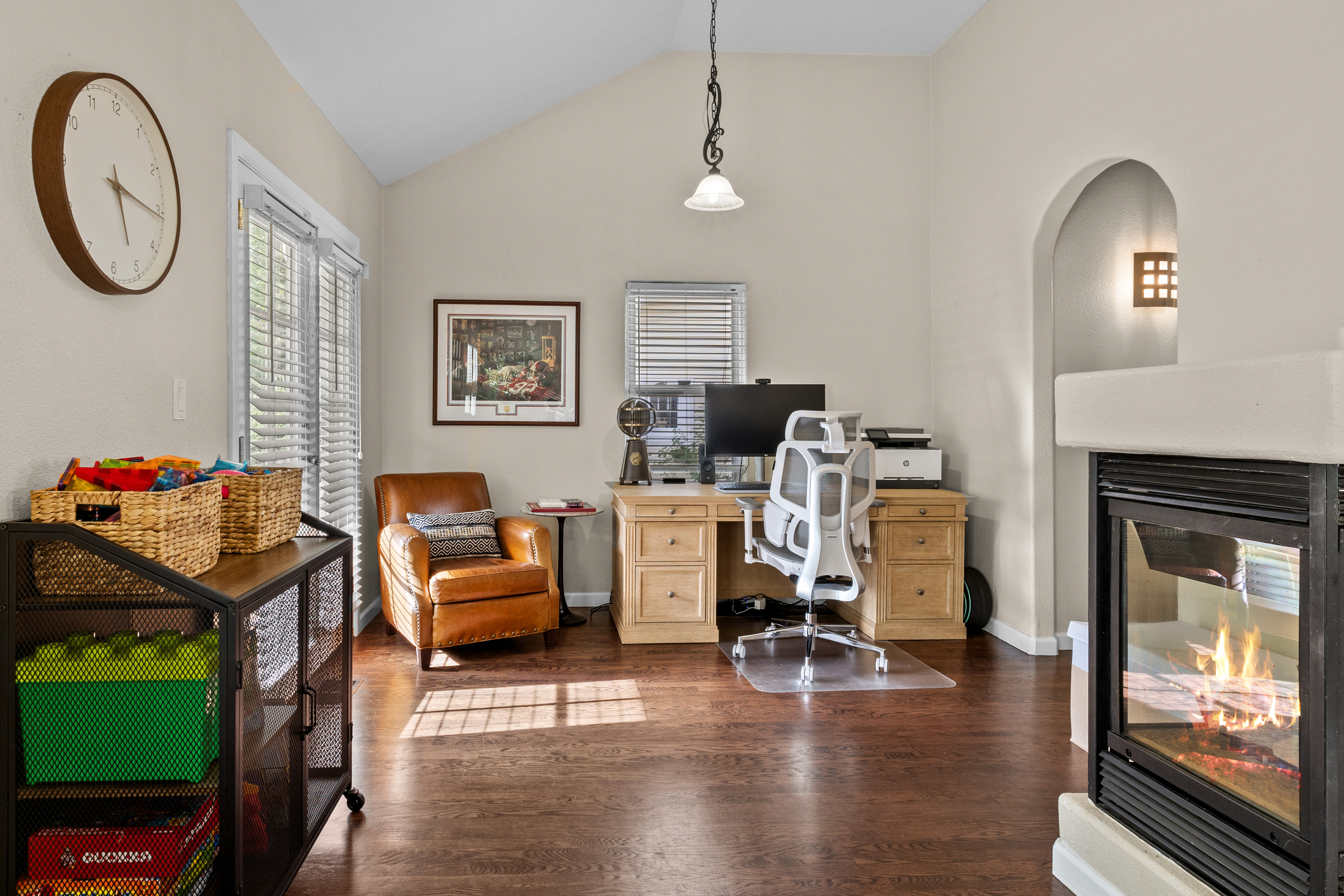 Off to the side of the living room is an office space for remote workers, plus a cabinet with games for the family. 