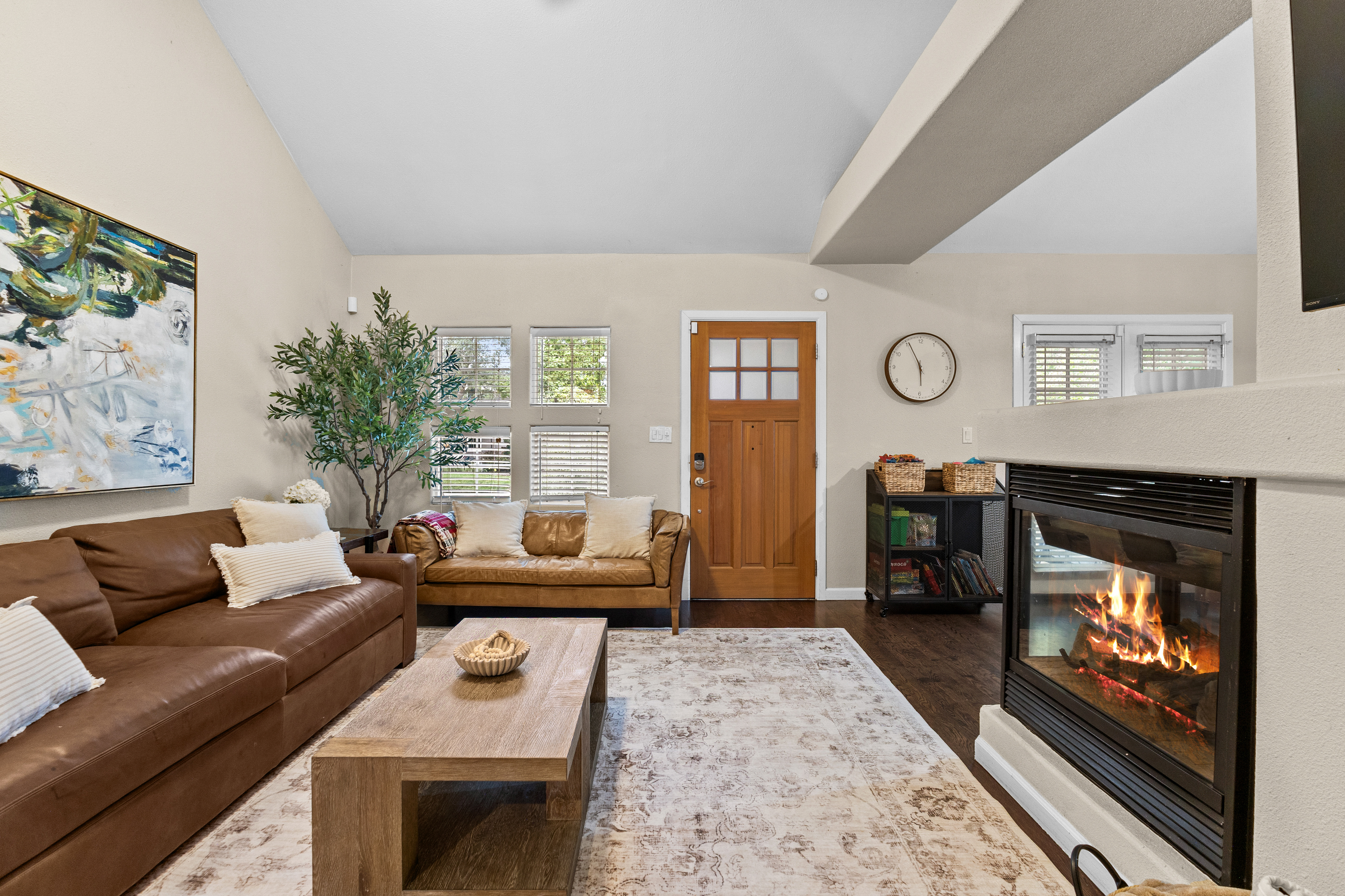 The living room includes a gas fireplace, a smart TV, and plenty of seating. 