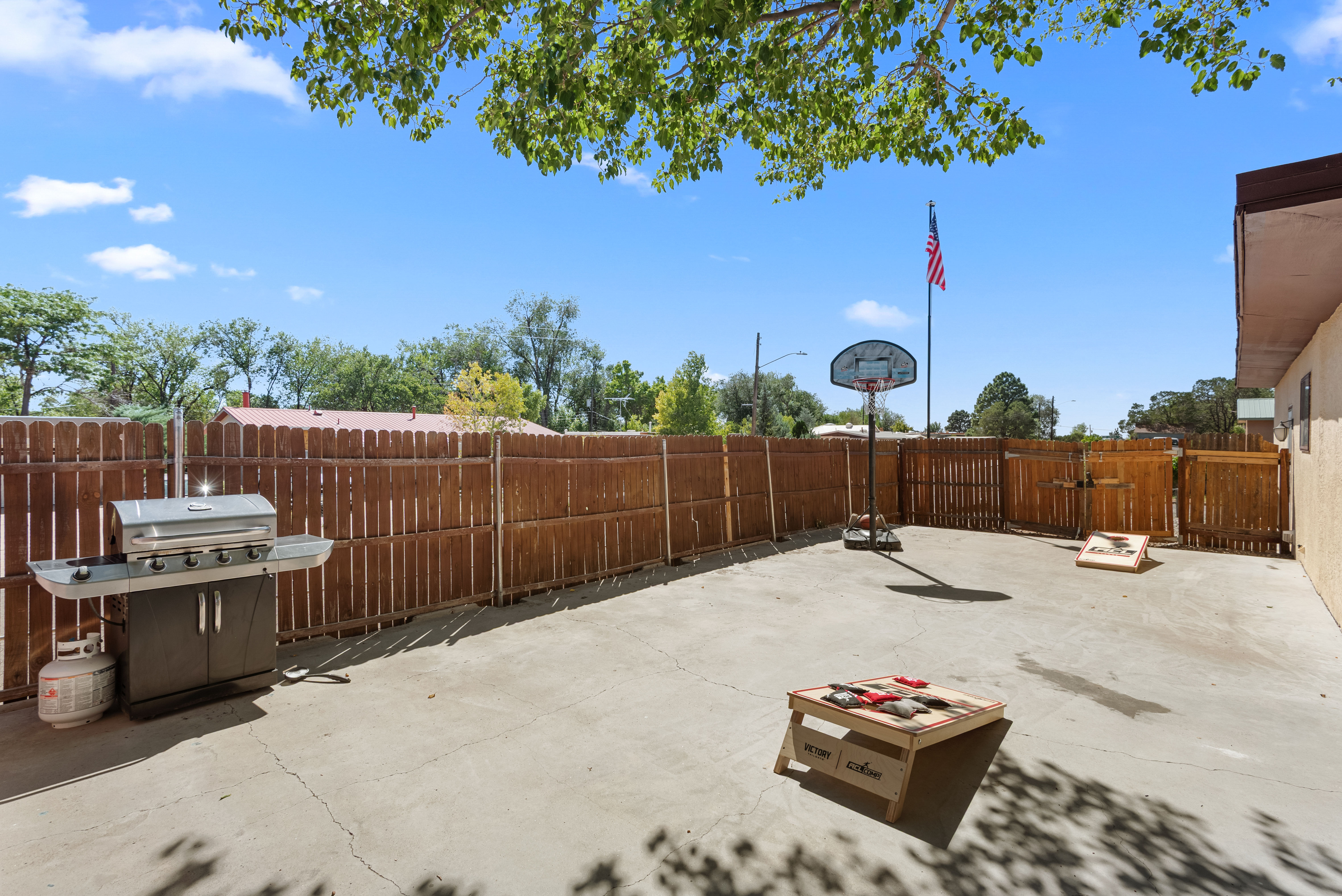 A fully fenced backyard with outdoor seating, a grill, hot tub, cornhole, and a basketball hoop! Plenty of space for your crew and your pets to roam.