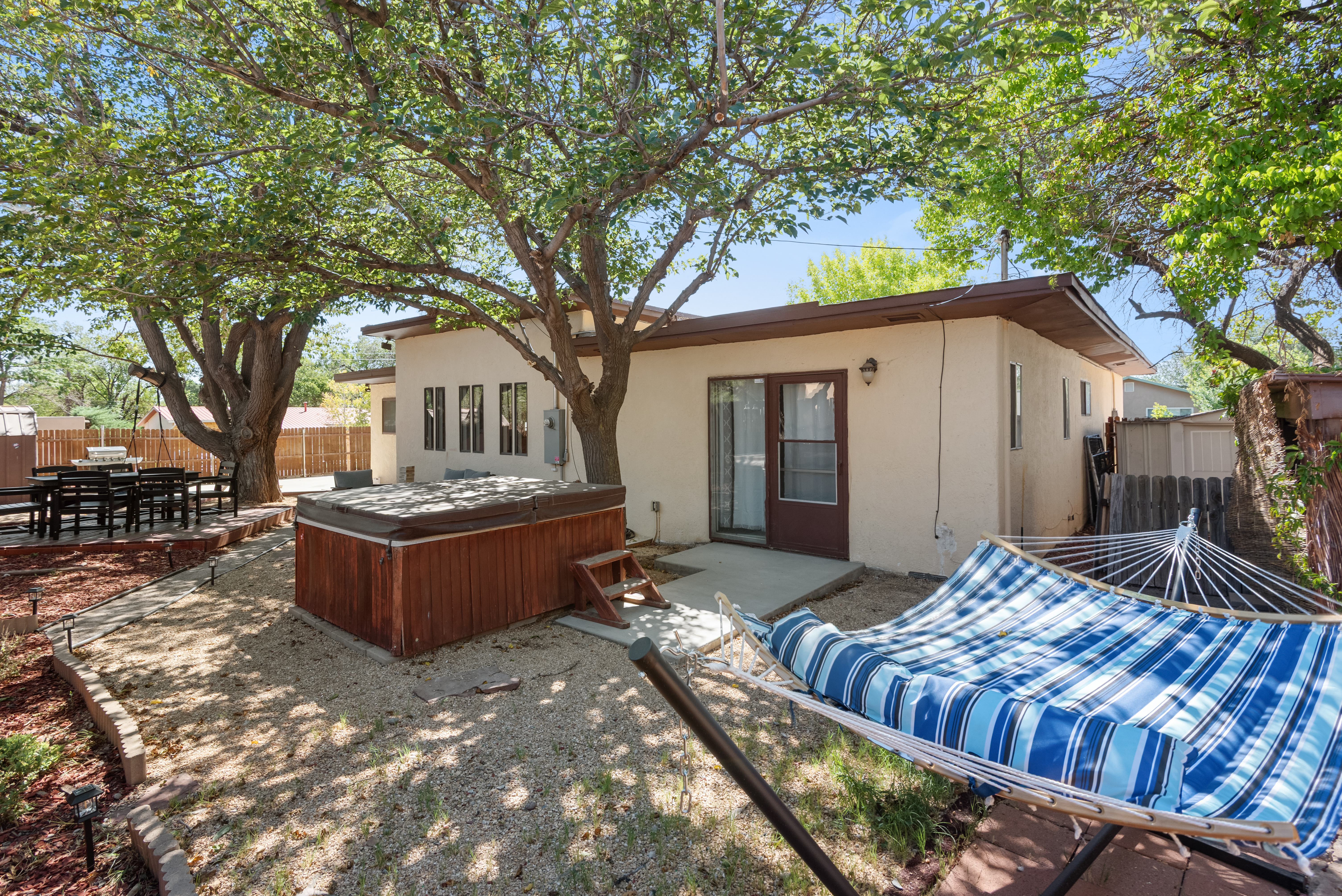 A fully fenced backyard with outdoor seating, a grill, hot tub, cornhole, and a basketball hoop! Plenty of space for your crew and your pets to roam.