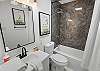 Full bathroom with convenient tub/shower combo and modern finishes.