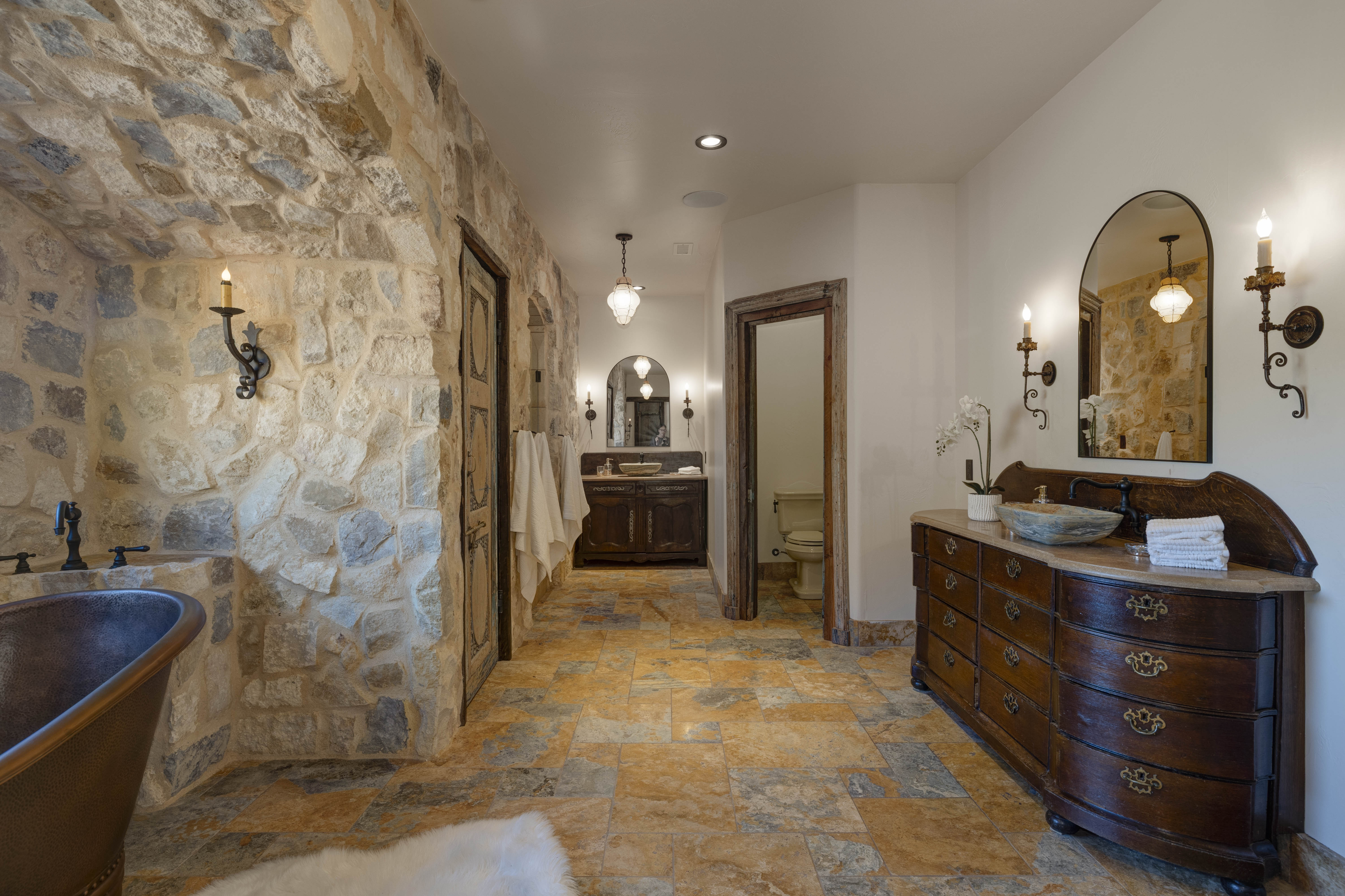 The luxury en suite bathroom includes a copper tub, large walk-in shower, and dual sinks. 