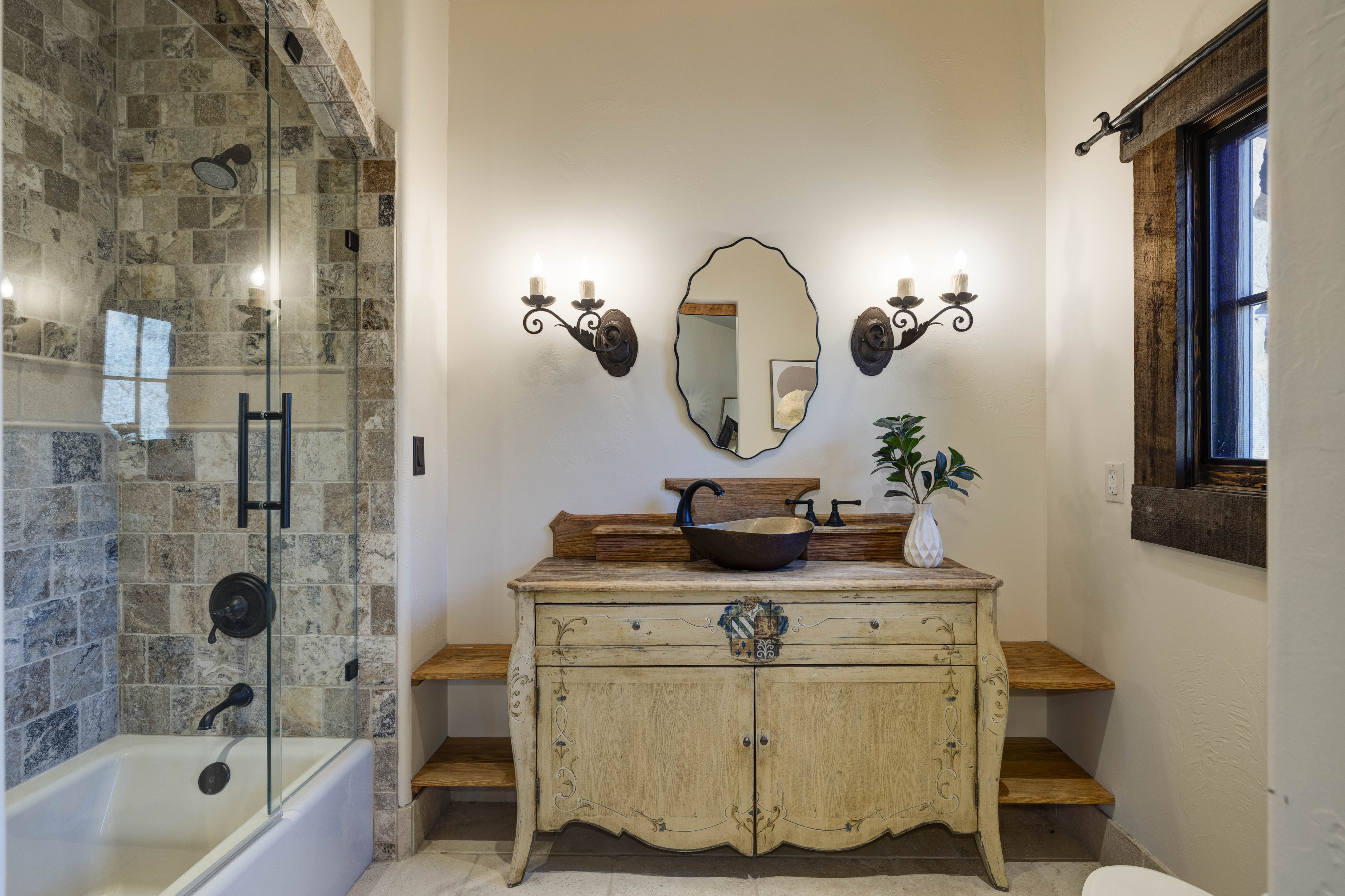 En suite bath with a convenient tub/shower combo and modern finishes.
