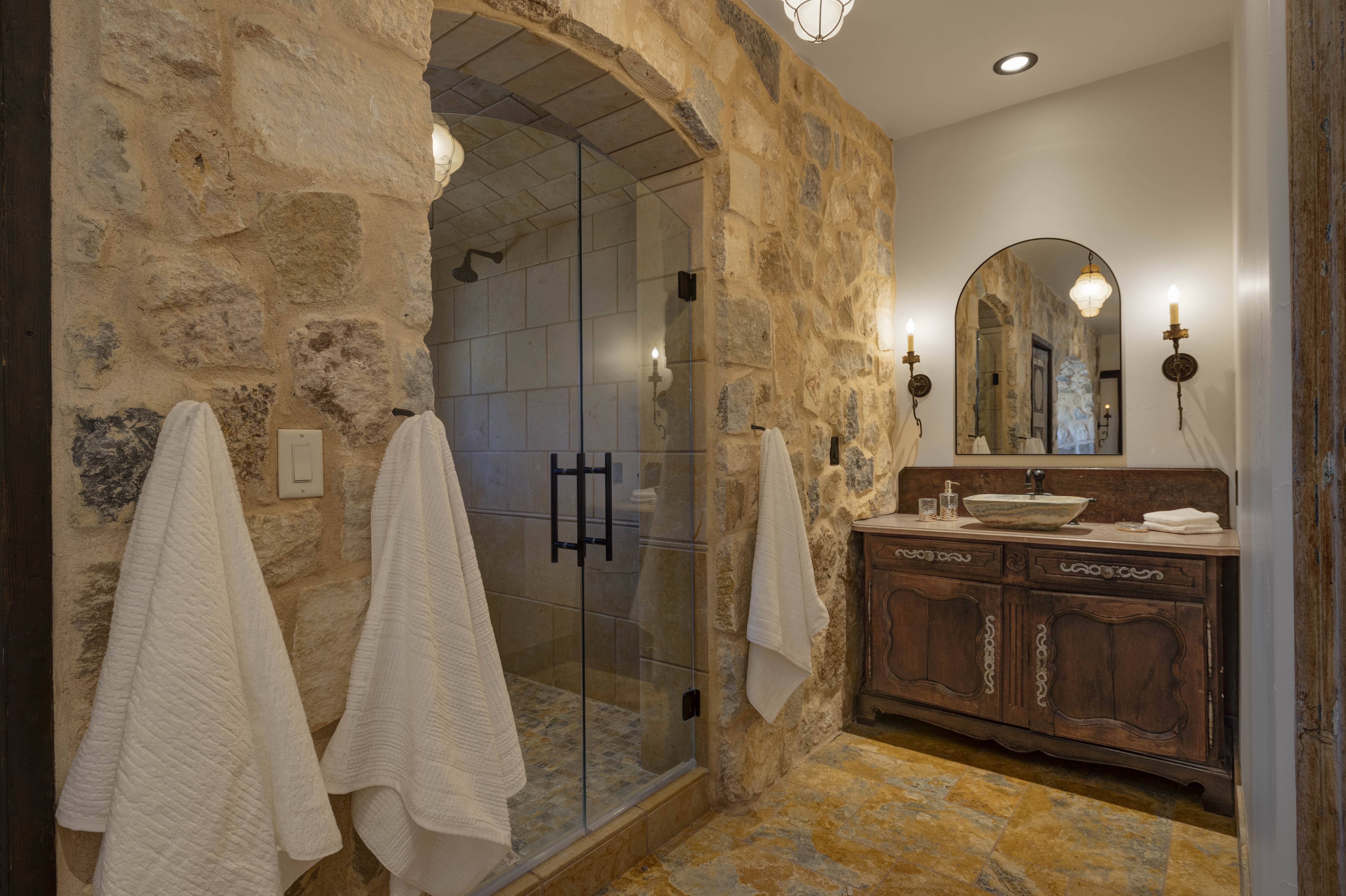 The luxury en suite bathroom includes a copper tub, large walk-in shower, and dual sinks. 