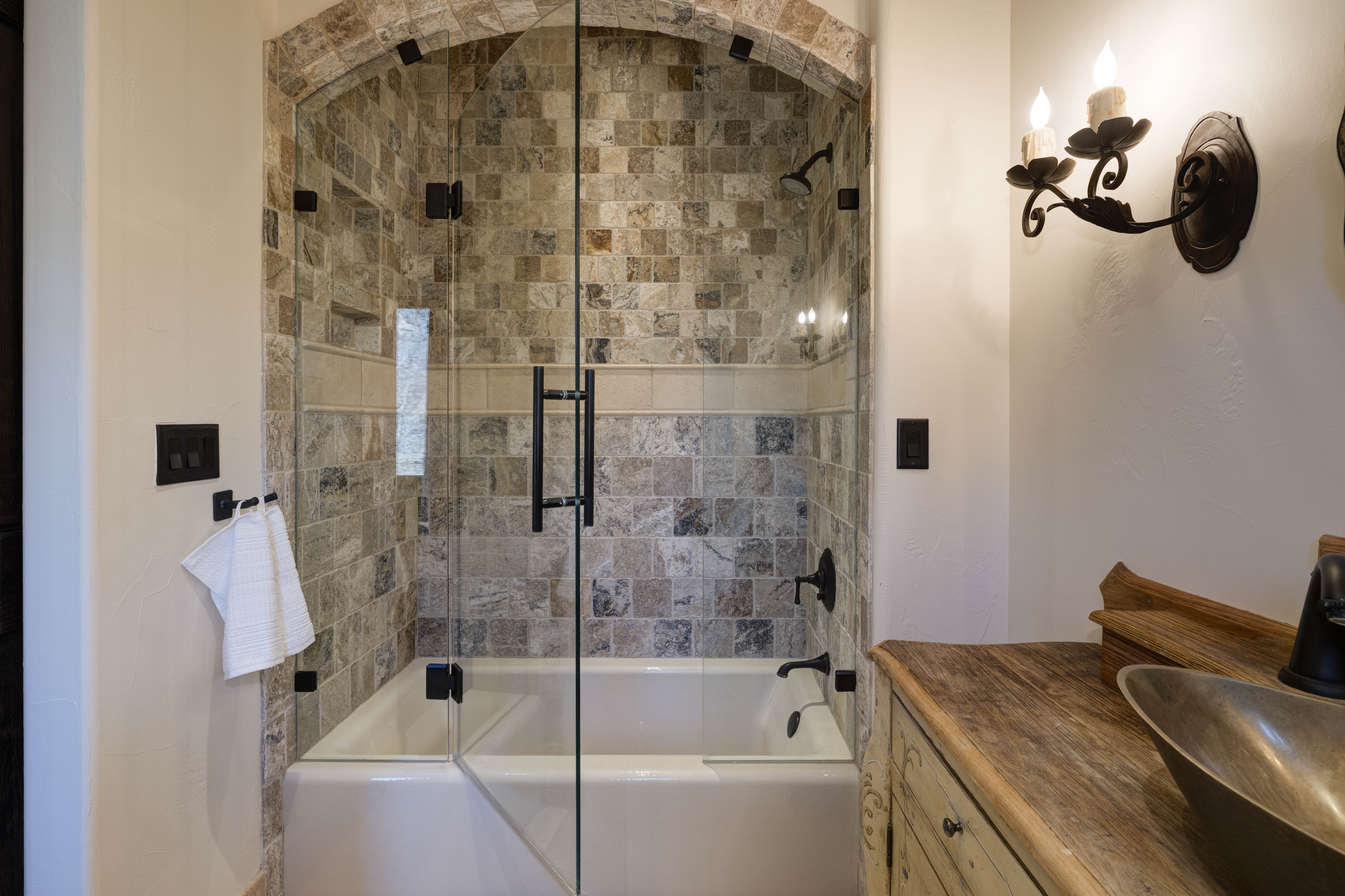 En suite bath with a convenient tub/shower combo and modern finishes.