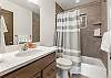 Full bathroom with convenient tub/shower combo and modern finishes.