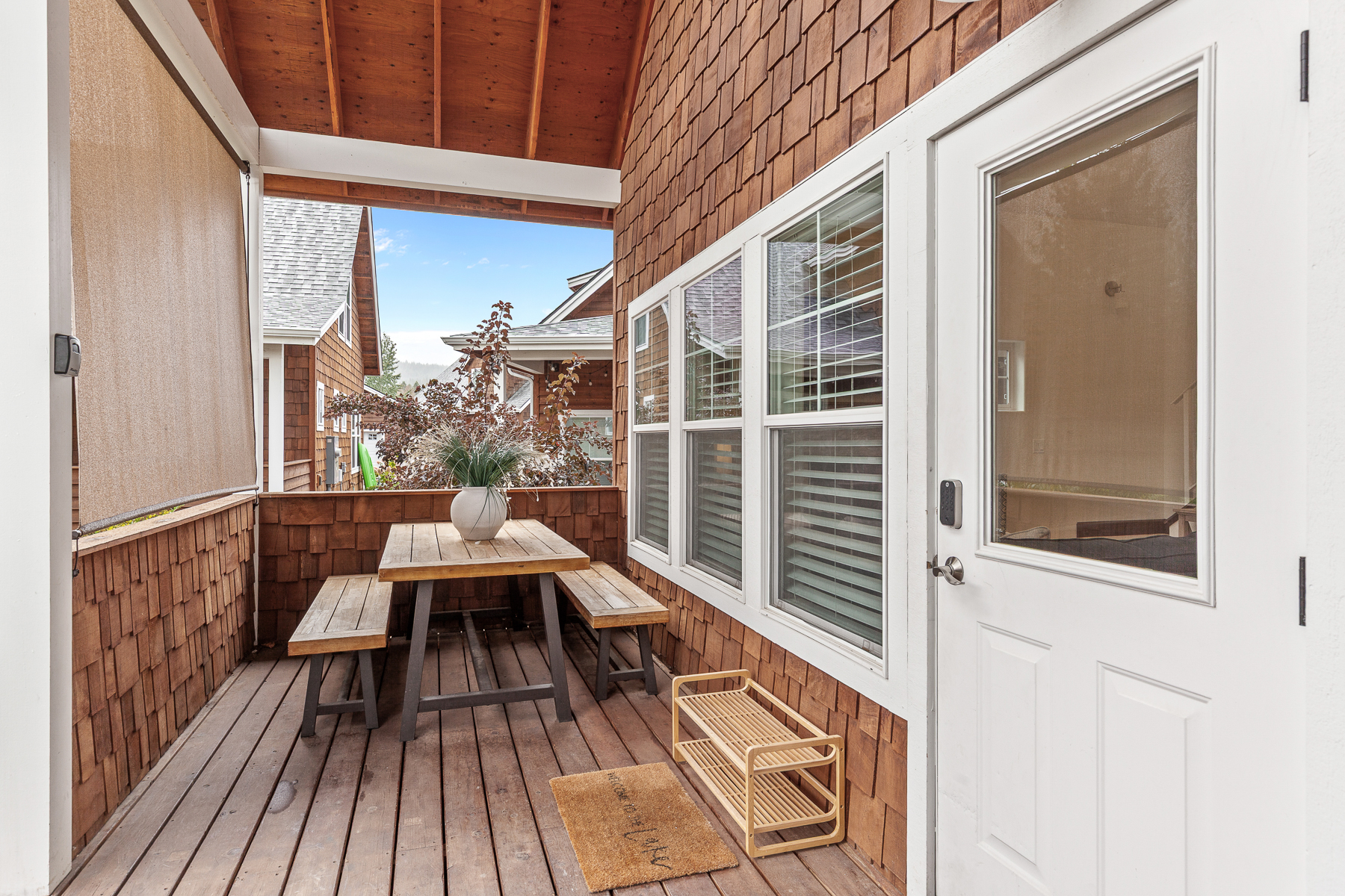 Covered deck with outdoor seating and grill. 