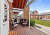 Covered deck with outdoor seating and grill. 