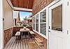 Covered deck with outdoor seating and grill. 