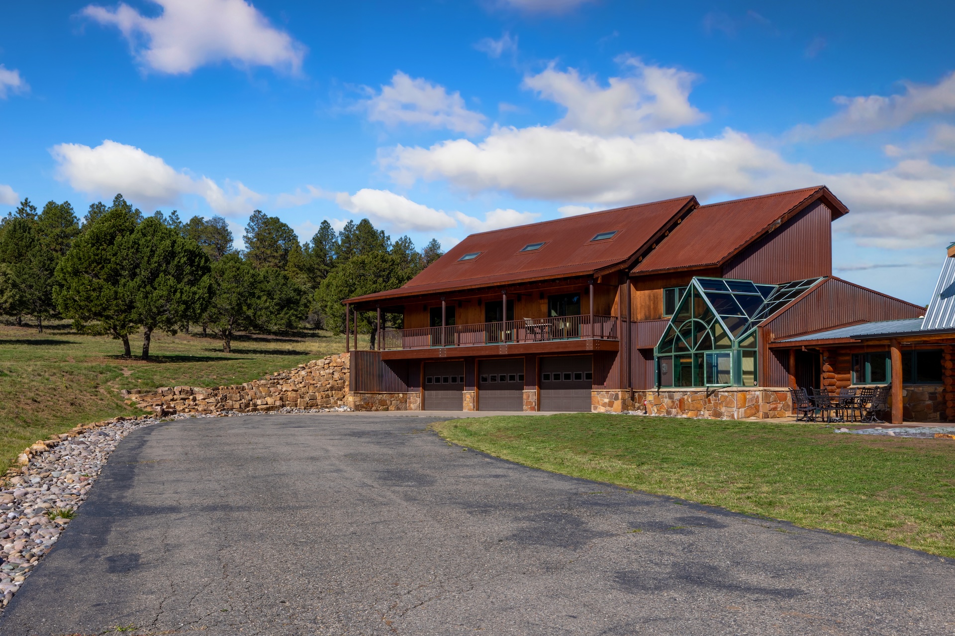 The home is surrounded by forest and mountain views.