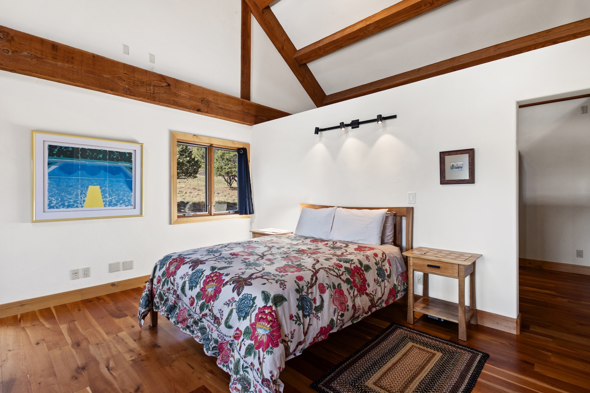 The primary sleeping area features a queen bed within the open-concept living space, with a privacy partition for added separation