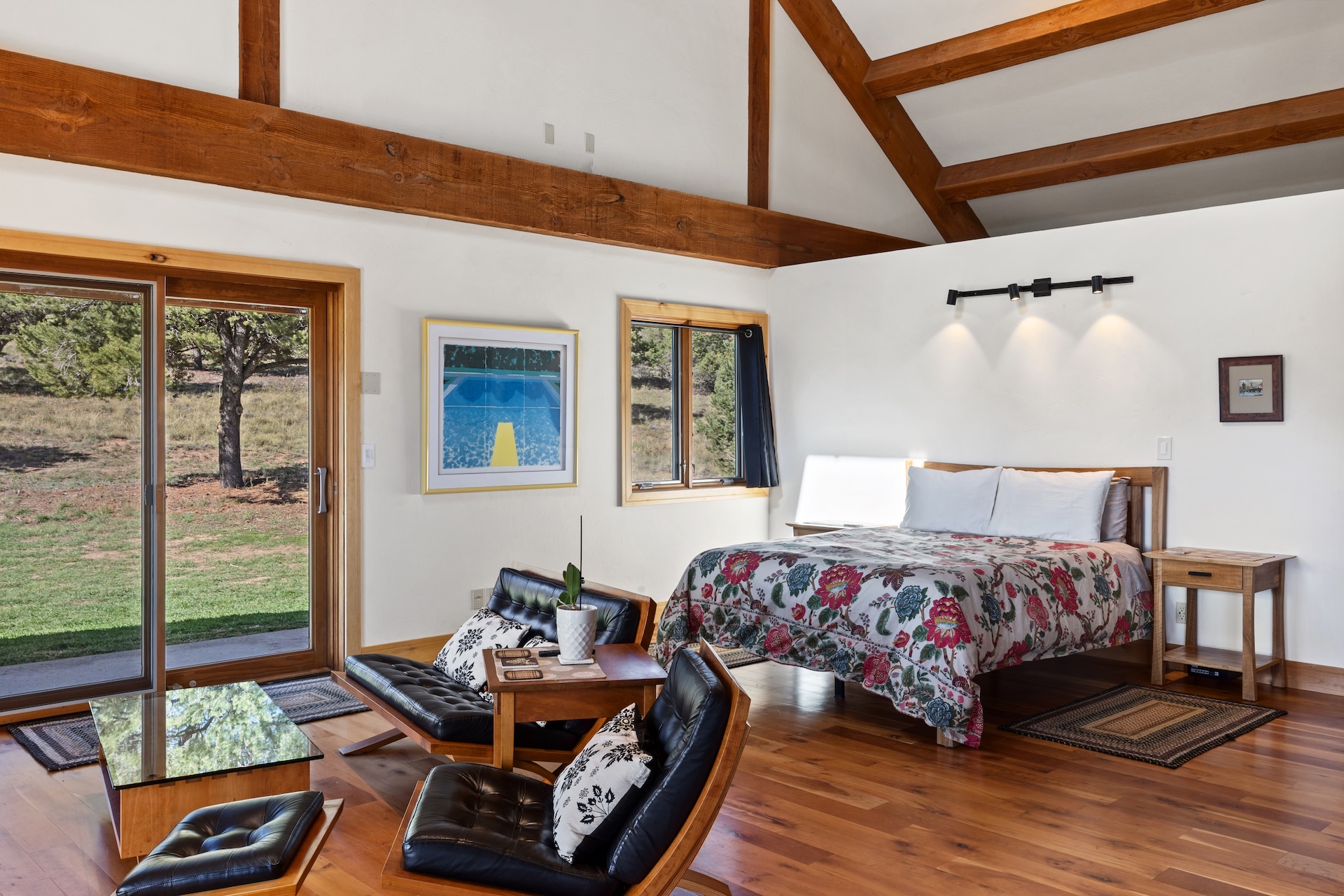 The primary sleeping area features a queen bed within the open-concept living space, with a privacy partition for added separation
