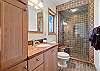 The private guest bathroom features a sleek, walk-in shower. 