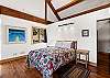 The primary sleeping area features a queen bed within the open-concept living space, with a privacy partition for added separation