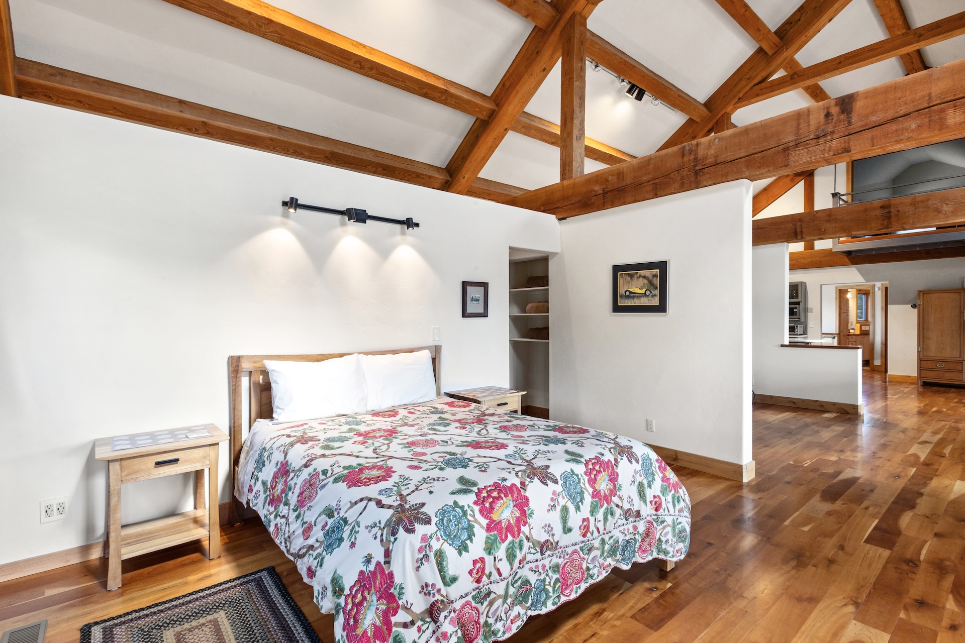 The primary sleeping area features a queen bed within the open-concept living space, with a privacy partition for added separation