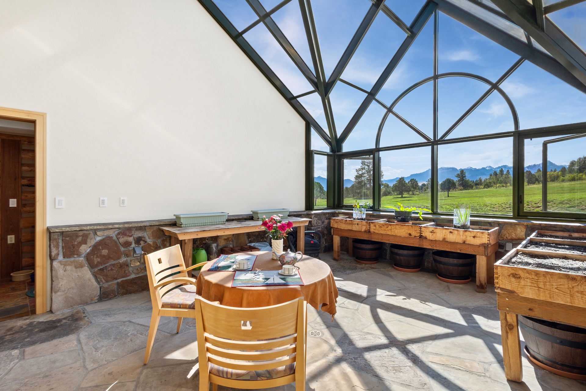 The all-glass greenhouse with a café table is the perfect spot to enjoy morning coffee or watch the stars.